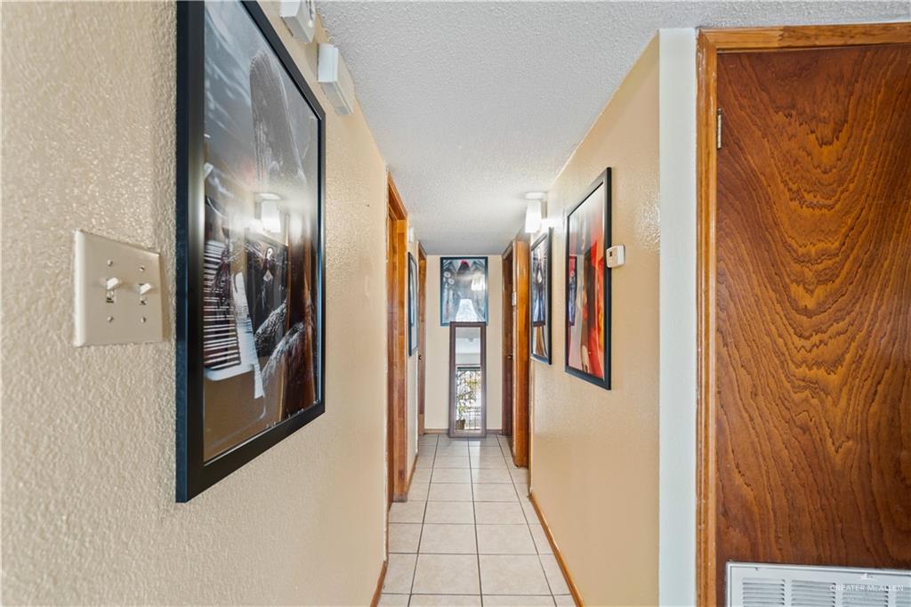 106 Rosa Priego Street Donna, TX 78537 - Photo 8 of 25 Corridor with a textured ceiling and light tile patterned floors