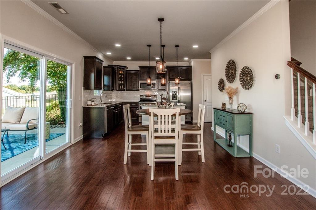 107 East Neel Ranch Road Mooresville, NC 28115 - Photo 21 of 48 a kitchen with stainless steel appliances kitchen island granite countertop a table and chairs in it