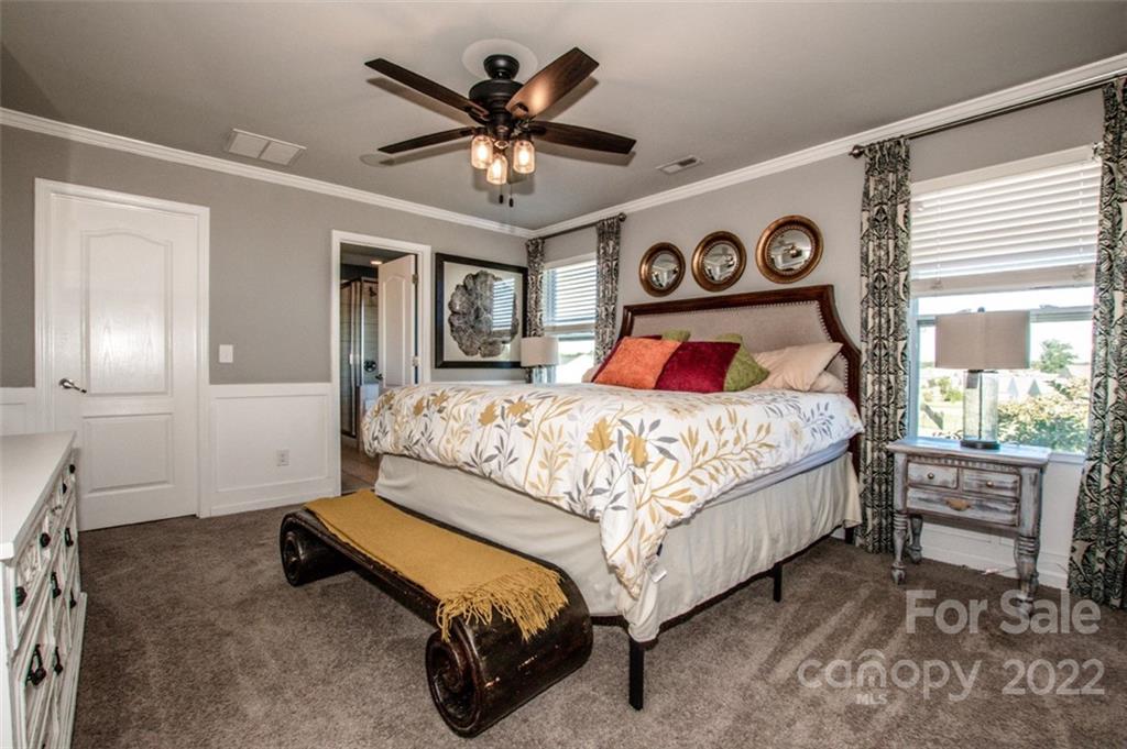 107 East Neel Ranch Road Mooresville, NC 28115 - Photo 25 of 48 a bedroom with a bed and a chandelier