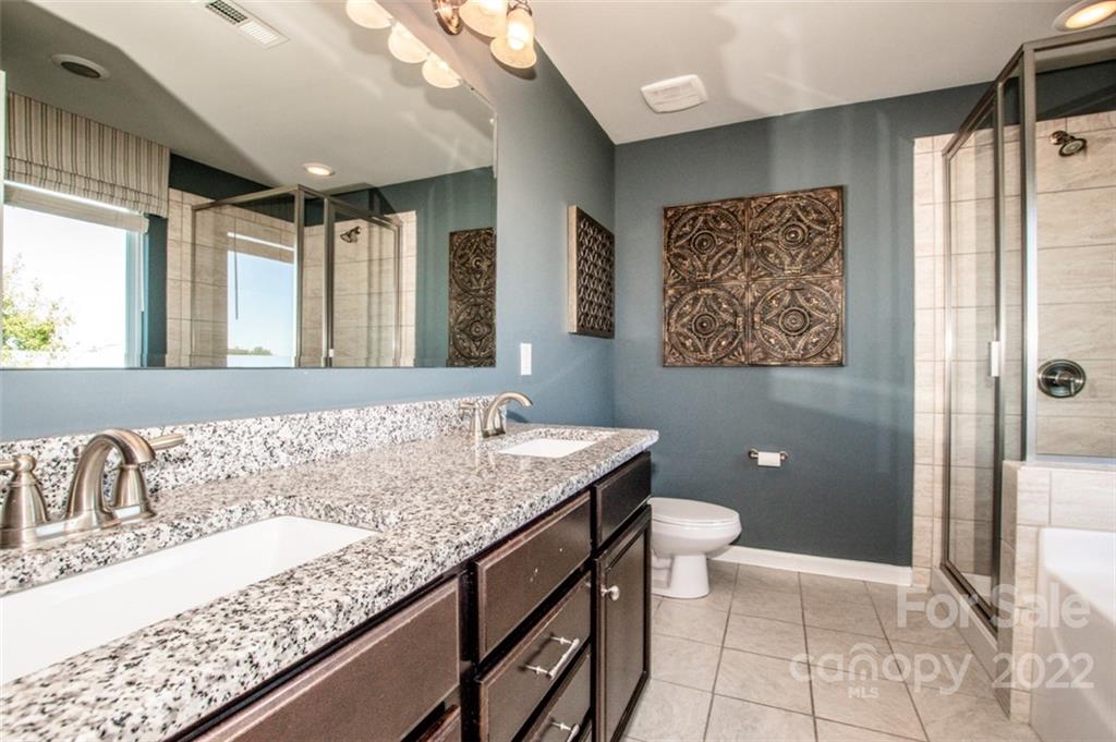 107 East Neel Ranch Road Mooresville, NC 28115 - Photo 27 of 48 a bathroom with a granite countertop sink a toilet a mirror and shower