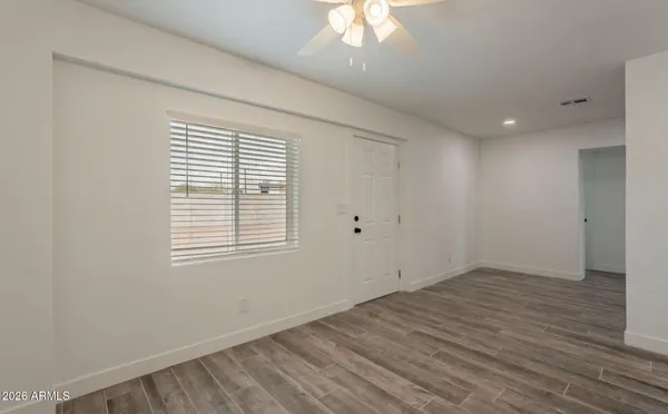 an empty room with wooden floor and windows