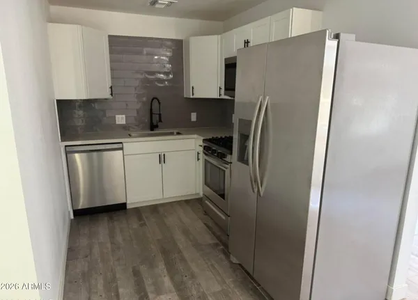 a kitchen with stainless steel appliances a refrigerator sink and microwave