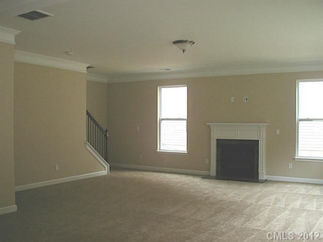 79115 Ridgehaven Road, Unit 161 Lancaster, SC 29720 - Photo 6 of 8 an empty room with a fireplace and windows