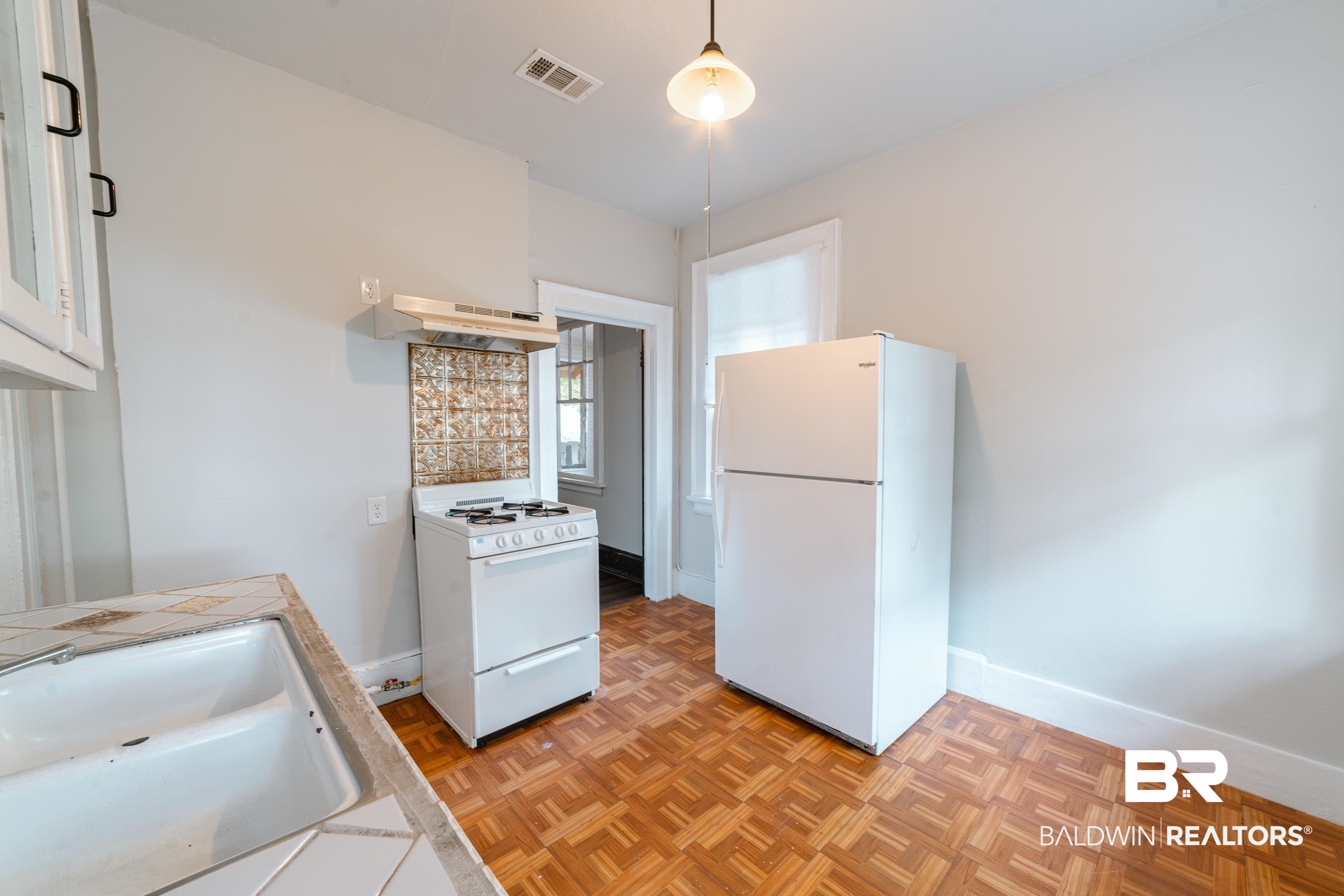 312 1st Street Mobile, AL 36611 - Photo 12 of 29 Kitchen featuring hanging light fixtures, white cabinetry, range hood, sink, and white appliances