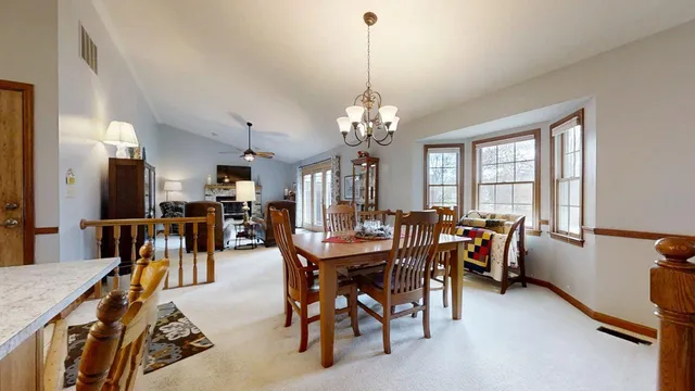 a view of a dining room with furniture and a chandelier