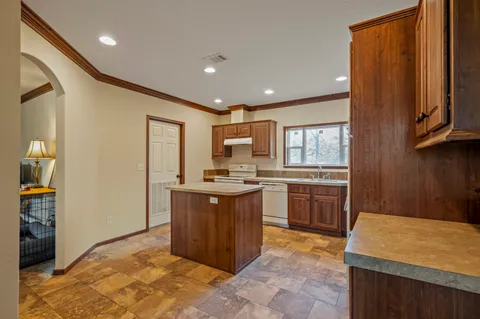 a kitchen with stainless steel appliances granite countertop a refrigerator and a stove top oven