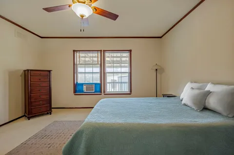 a spacious bedroom with a large bed and a chandelier