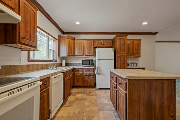 a kitchen with a sink a refrigerator and a stove top oven