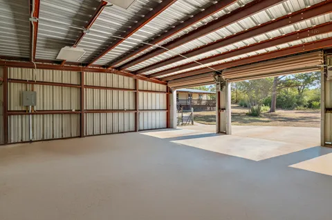 a view of an empty room with wooden floor and stairs