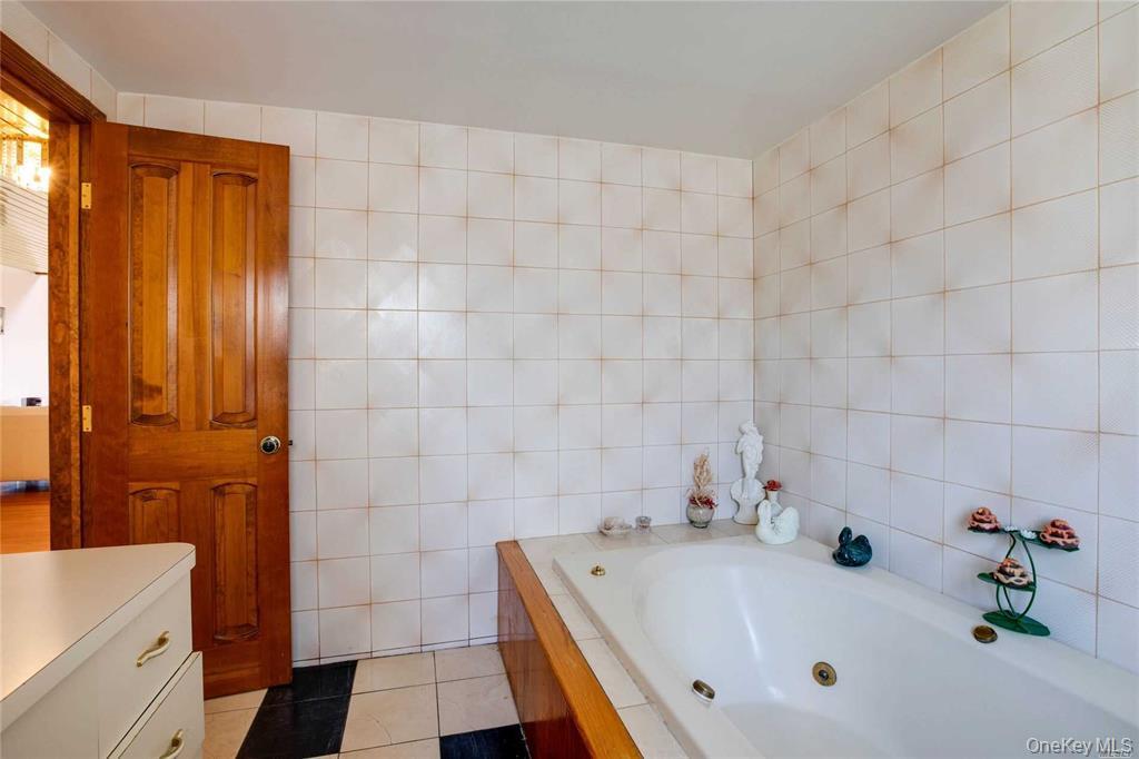 2-44 149th Street Queens, NY 11357 - Photo 13 of 20 a bathroom with a tub a sink and a shower