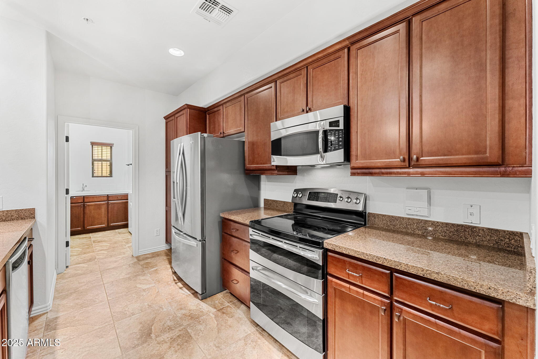 3935 East Rough Rider Road, Unit 1235 Phoenix, AZ 85050 - Photo 11 of 52 a kitchen with stainless steel appliances granite countertop a refrigerator stove and microwave