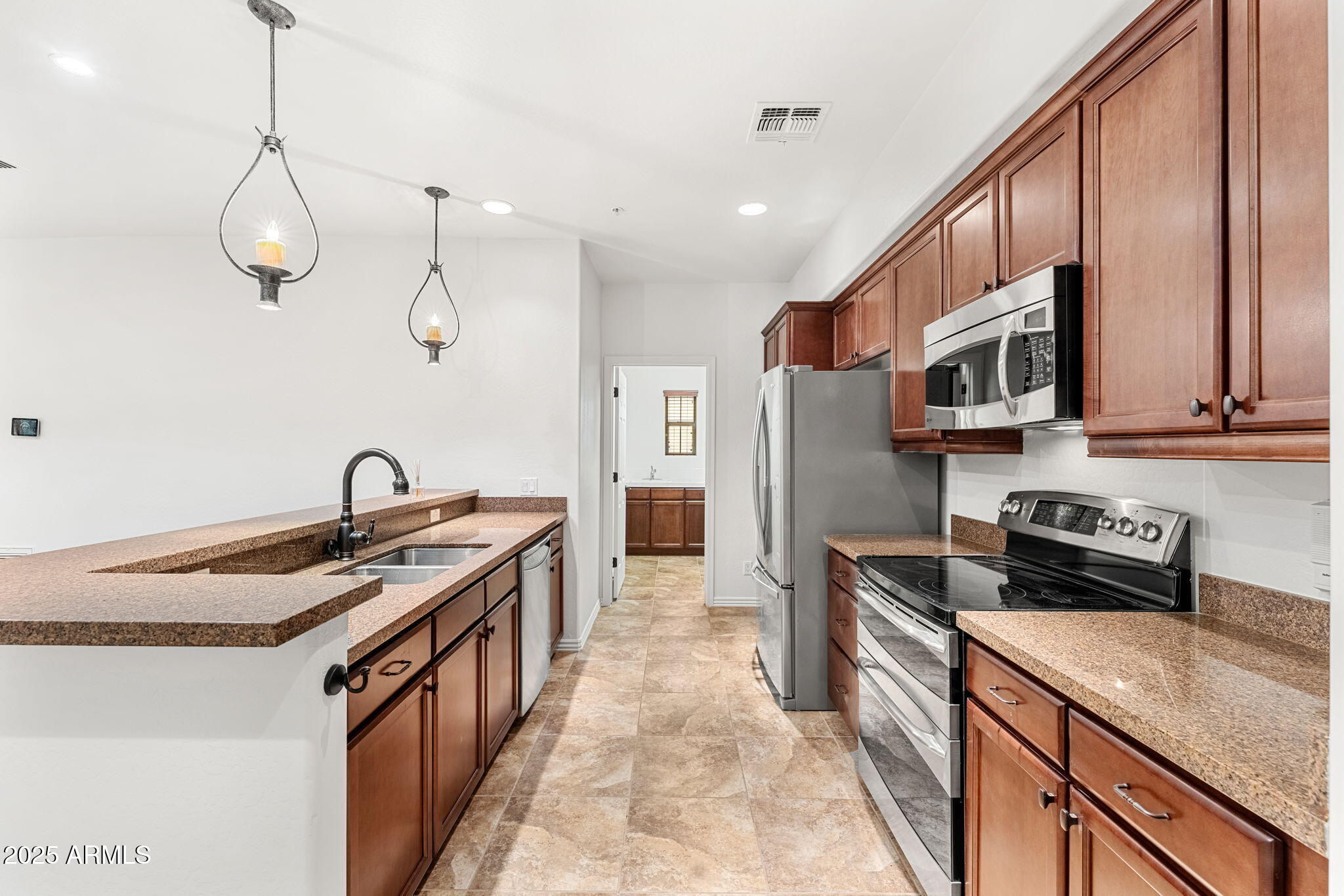 3935 East Rough Rider Road, Unit 1235 Phoenix, AZ 85050 - Photo 12 of 52 a kitchen with stainless steel appliances granite countertop a sink stove and refrigerator