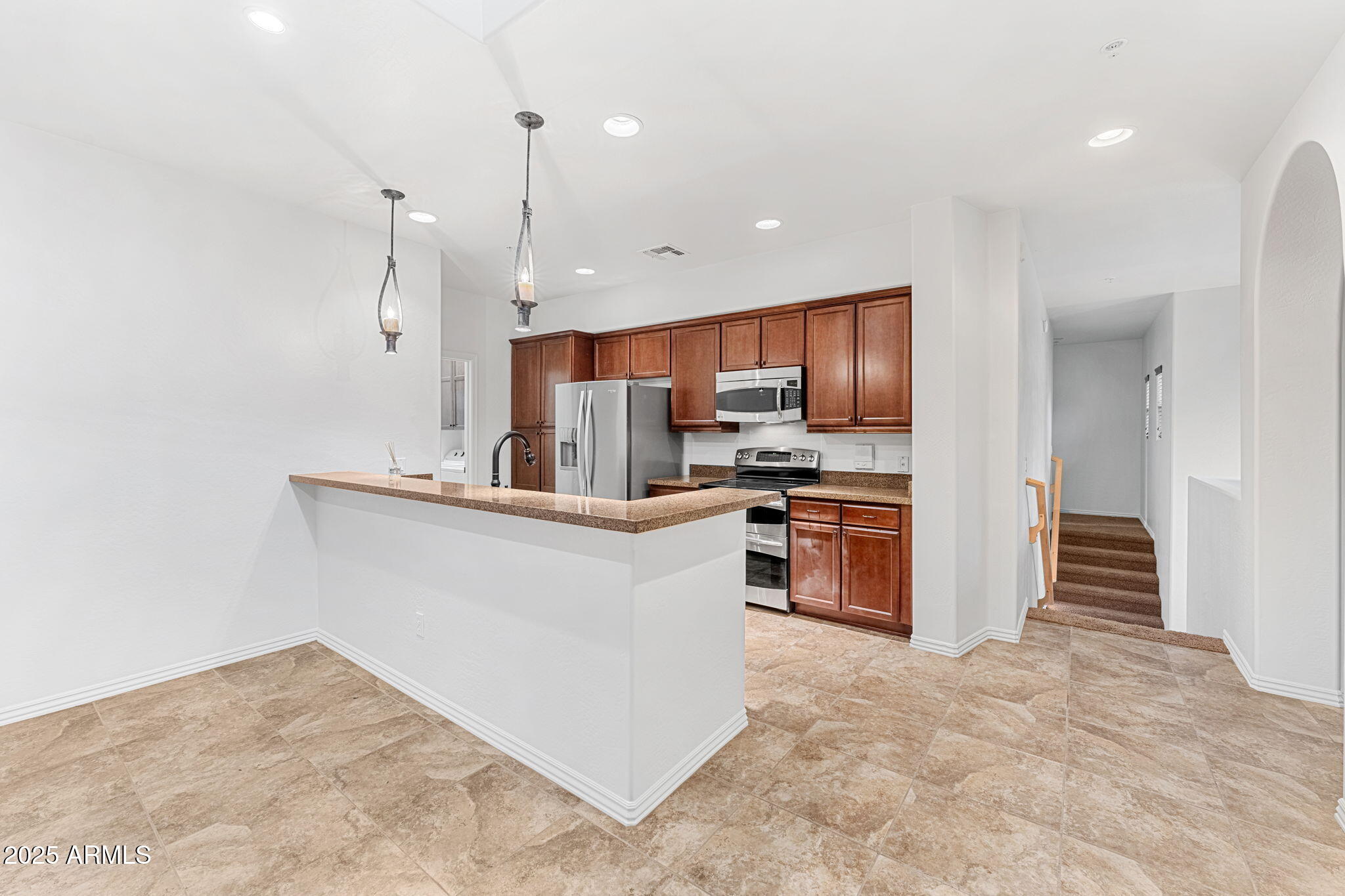 3935 East Rough Rider Road, Unit 1235 Phoenix, AZ 85050 - Photo 7 of 52 a kitchen with stainless steel appliances a refrigerator and a stove top oven