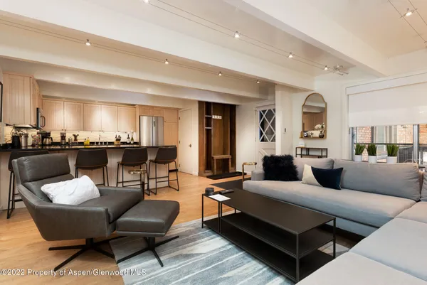 a living room with furniture and view of kitchen