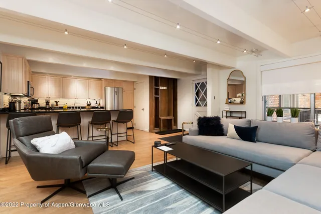 a living room with furniture and view of kitchen