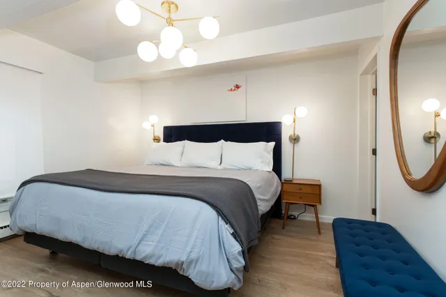 a bedroom with a bed a mirror and a potted plant
