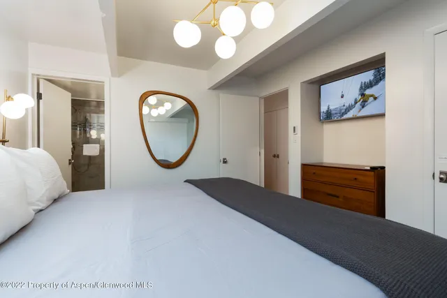 a bedroom with a bed and a mirror