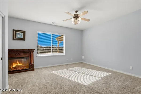 a view of an empty room with window and fire place