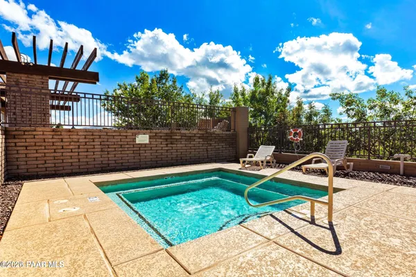 a view of a chair and tables in the back yard of the house