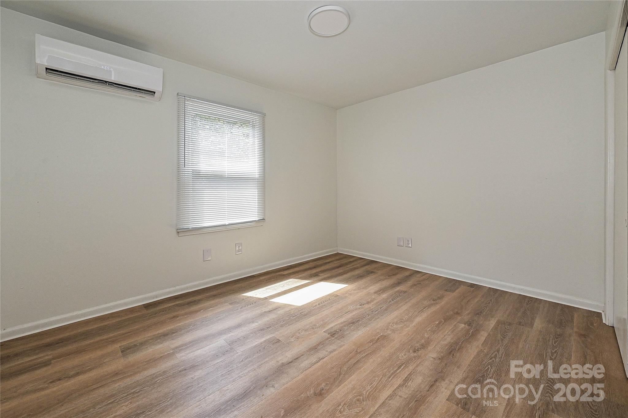 260 Church Street North, Unit 2 Concord, NC 28025 - Photo 11 of 12 an empty room with wooden floor and windows