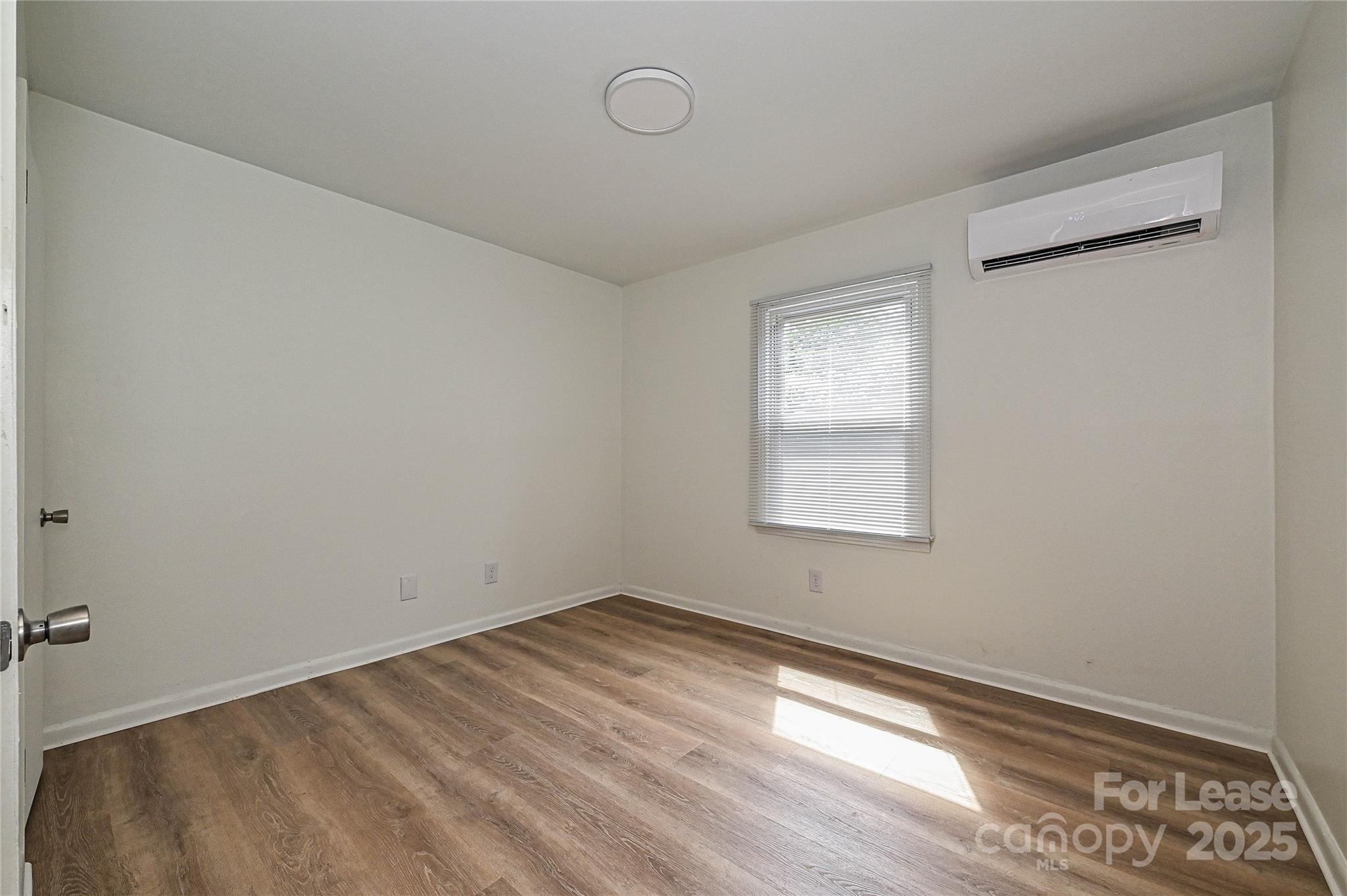 260 Church Street North, Unit 2 Concord, NC 28025 - Photo 9 of 12 a view of an empty room with wooden floor and a window