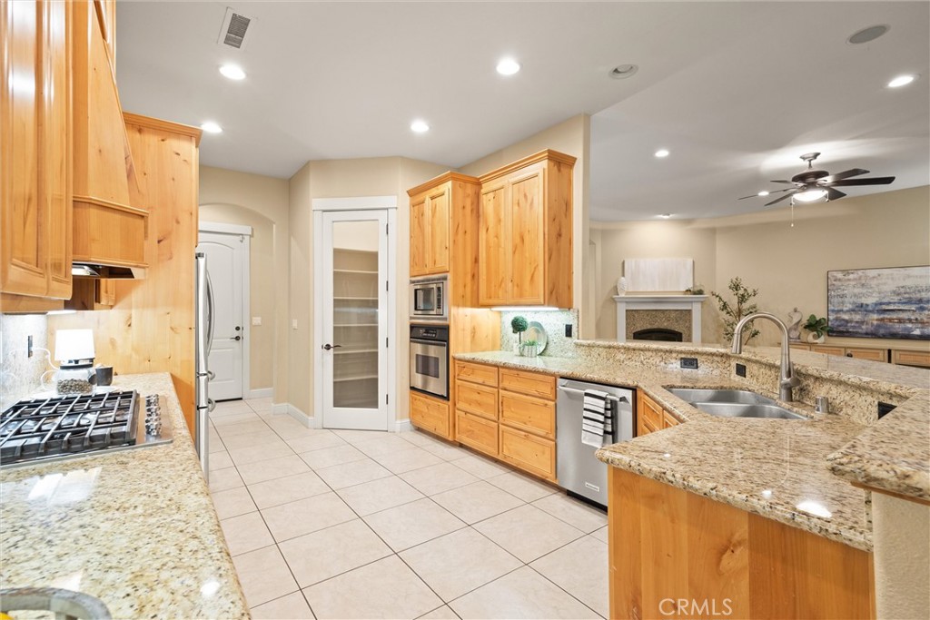 10473 Bogie Way Chico, CA 95928 - Photo 27 of 46 a large kitchen with kitchen island granite countertop a large counter top stainless steel appliances and cabinets