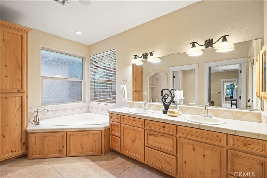 10473 Bogie Way Chico, CA 95928 - Photo 34 of 46 a bathroom with a tub sink and mirror