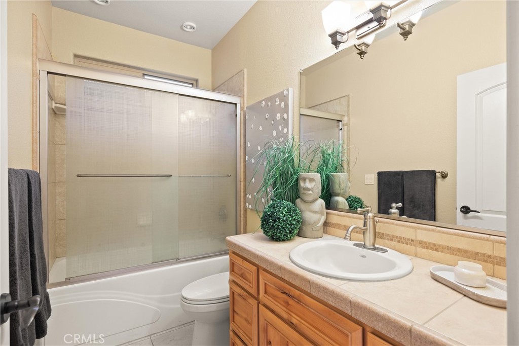 10473 Bogie Way Chico, CA 95928 - Photo 37 of 46 a bathroom with a sink a toilet a mirror and shower