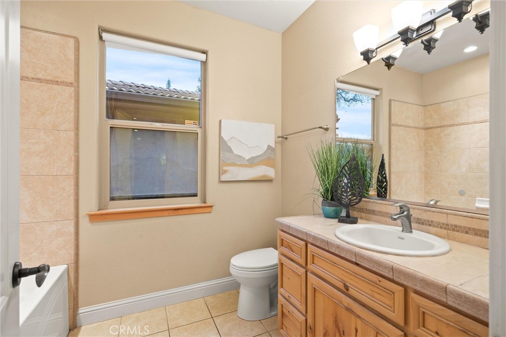 10473 Bogie Way Chico, CA 95928 - Photo 40 of 46 a bathroom with a granite countertop sink toilet and a mirror