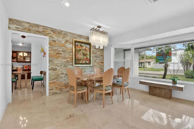 a dining room with furniture a chandelier and wooden floor