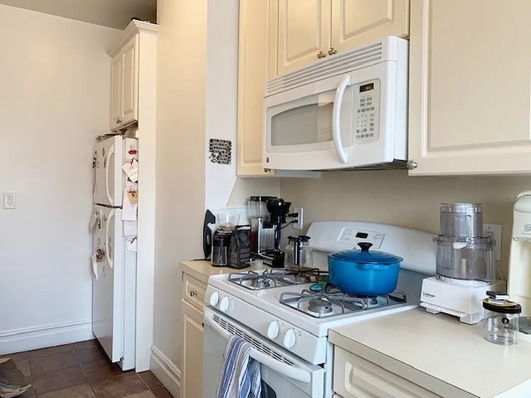 425 Riverside Drive, Unit 6J Manhattan, NY 10025 - Photo 4 of 17 a kitchen with stainless steel appliances granite countertop a stove and a refrigerator