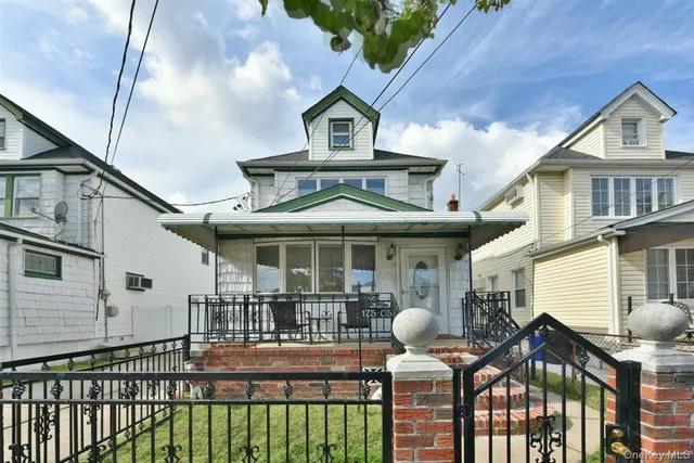 a front view of a house with glass windows and fence