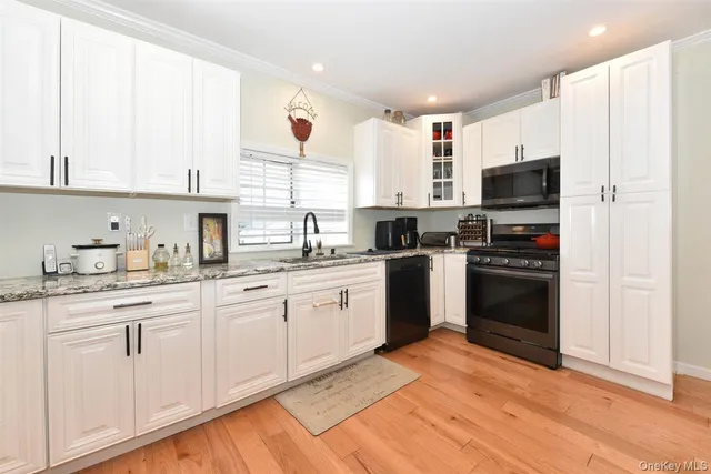 a kitchen with stainless steel appliances granite countertop a refrigerator sink and white cabinets