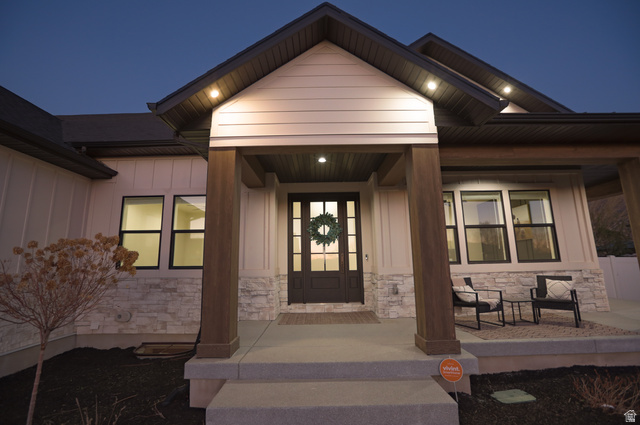 126 North 800 West Mapleton, UT 84664 - Photo 77 of 79 Exterior entry at night featuring stone siding, a porch, and board and batten siding