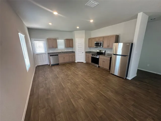 a kitchen with stainless steel appliances a refrigerator and a stove top oven