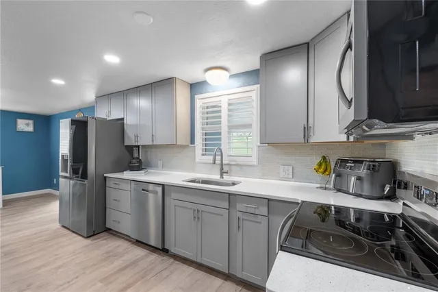 a kitchen with stainless steel appliances a refrigerator and a microwave