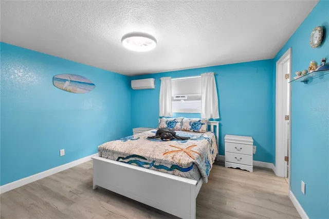 a bedroom with a bed and a painting on the wall