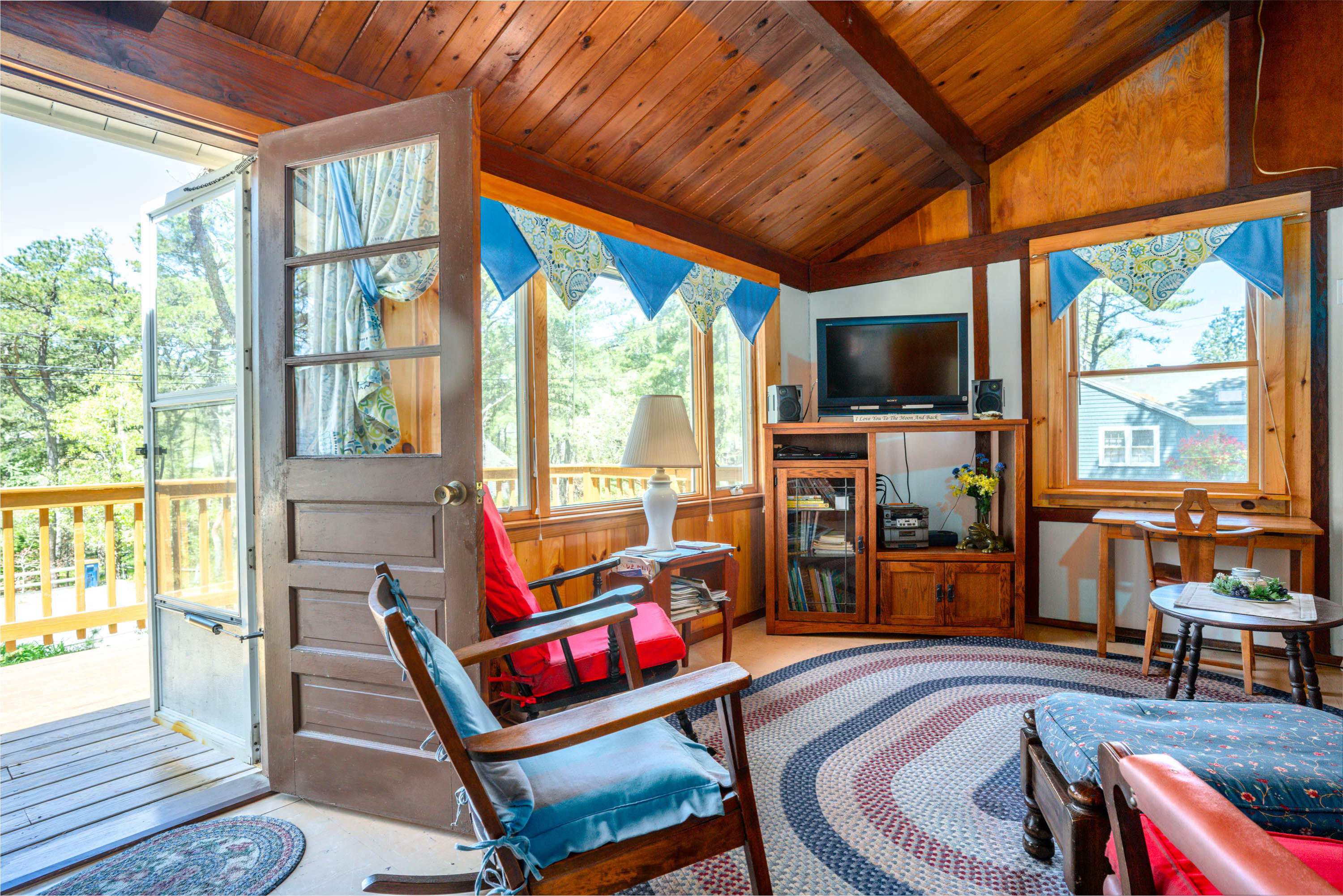 45 King Phillip Road Wellfleet, MA 02667 - Photo 13 of 22 a living room with furniture a flat screen tv and a floor to ceiling window