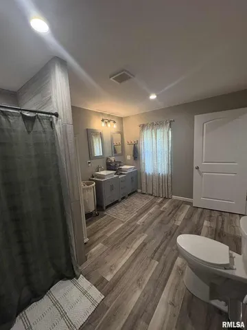 a spacious bathroom with a sink a toilet a mirror and shower
