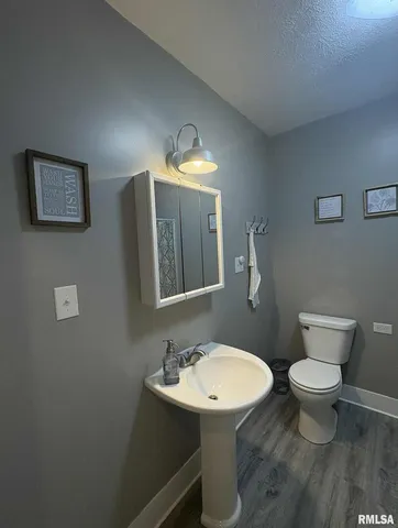 a bathroom with a toilet sink vanity and mirror