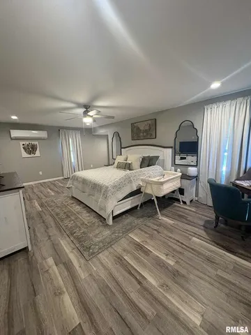 a bedroom with a bed wooden floor and window