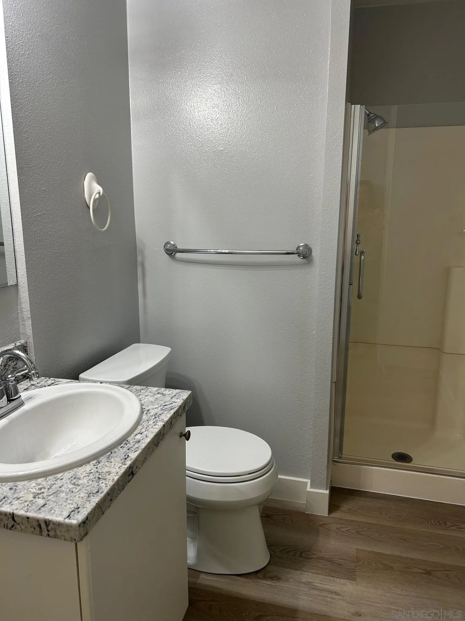 225 Melrose Avenue, Unit 2 Encinitas, CA 92024 - Photo 13 of 18 a bathroom with a granite countertop toilet a sink and a mirror