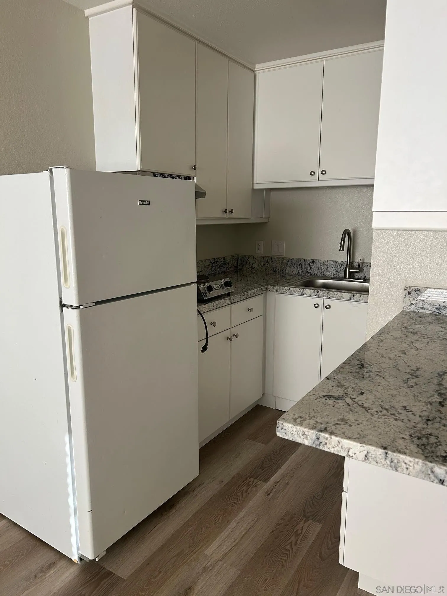 225 Melrose Avenue, Unit 2 Encinitas, CA 92024 - Photo 7 of 18 a kitchen with granite countertop a refrigerator and a sink