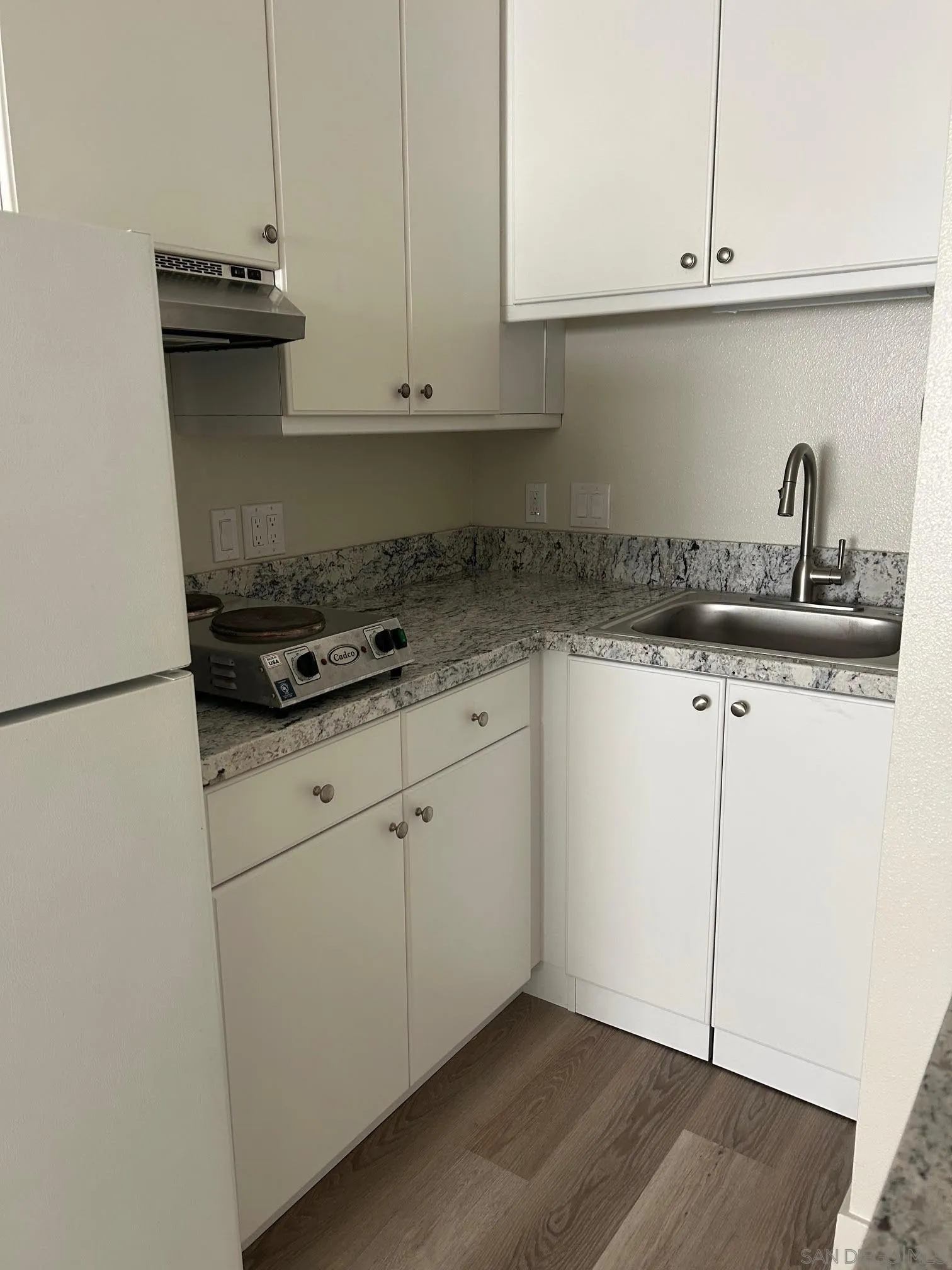 225 Melrose Avenue, Unit 2 Encinitas, CA 92024 - Photo 8 of 18 a kitchen with granite countertop white cabinets and white appliances