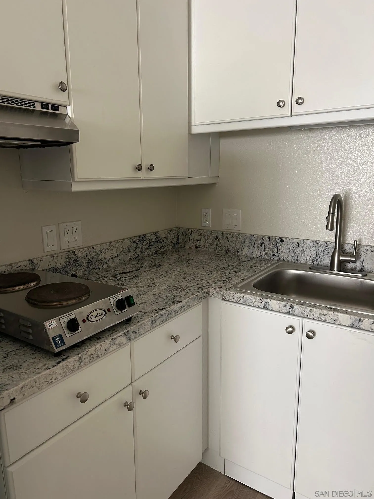 225 Melrose Avenue, Unit 2 Encinitas, CA 92024 - Photo 9 of 18 a kitchen with granite countertop a sink a stove and cabinets