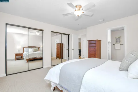 a bedroom with a bed and a large mirror