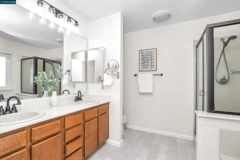 a bathroom with a double vanity sink mirror and shower