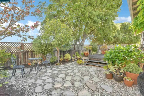 a view of a patio with chair and tables back yard of the house