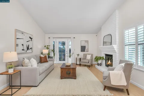 a living room with furniture fireplace and a large window