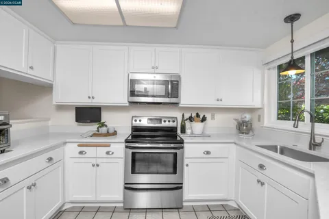 a kitchen with cabinets appliances a sink and a window